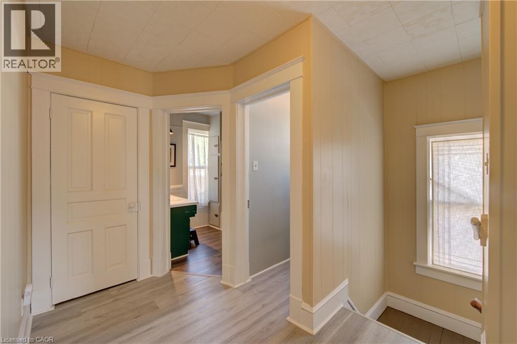 Hallway featuring wood-finish flooring, white paneled doors, and a window with white trim - 39 Kerr Street, Cambridge, ON - Indoor Photo Showing Other Room