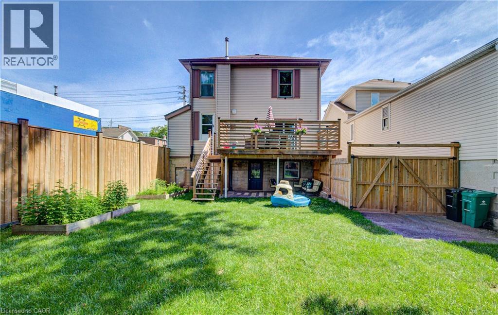 Expansive grassy yard with a multi-level wood deck featuring privacy railings - 39 Kerr Street, Cambridge, ON - Outdoor