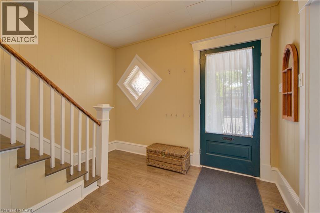 Entryway featuring a dark green paneled door with white trim, wood-finish flooring, and a staircase with white balusters and a wood-finish handrail - 39 Kerr Street, Cambridge, ON - Indoor Photo Showing Other Room