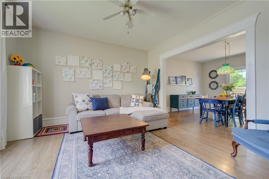 Open-concept living area featuring light wood-finish flooring, a ceiling fan, and a wide cased opening to the dining area - 39 Kerr Street, Cambridge, ON - Indoor Photo Showing Living Room