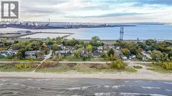 Expansive waterfront property featuring a sandy beach, mature trees, and direct access to Lake Ontario -