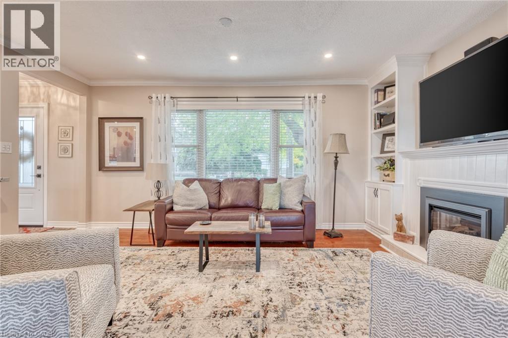 Living area featuring recessed lighting, hardwood flooring, a fireplace with a white mantel, and built-in shelving - 851 Beach Boulevard, Hamilton, ON - Indoor Photo Showing Living Room With Fireplace