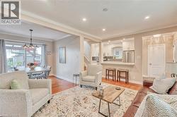 Bright living area featuring wood-finish flooring, recessed lighting, and crown molding -