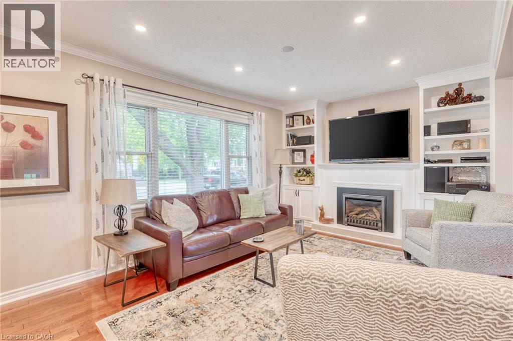 Living area featuring wood-finish flooring and crown molding - 851 Beach Boulevard, Hamilton, ON - Indoor Photo Showing Living Room With Fireplace