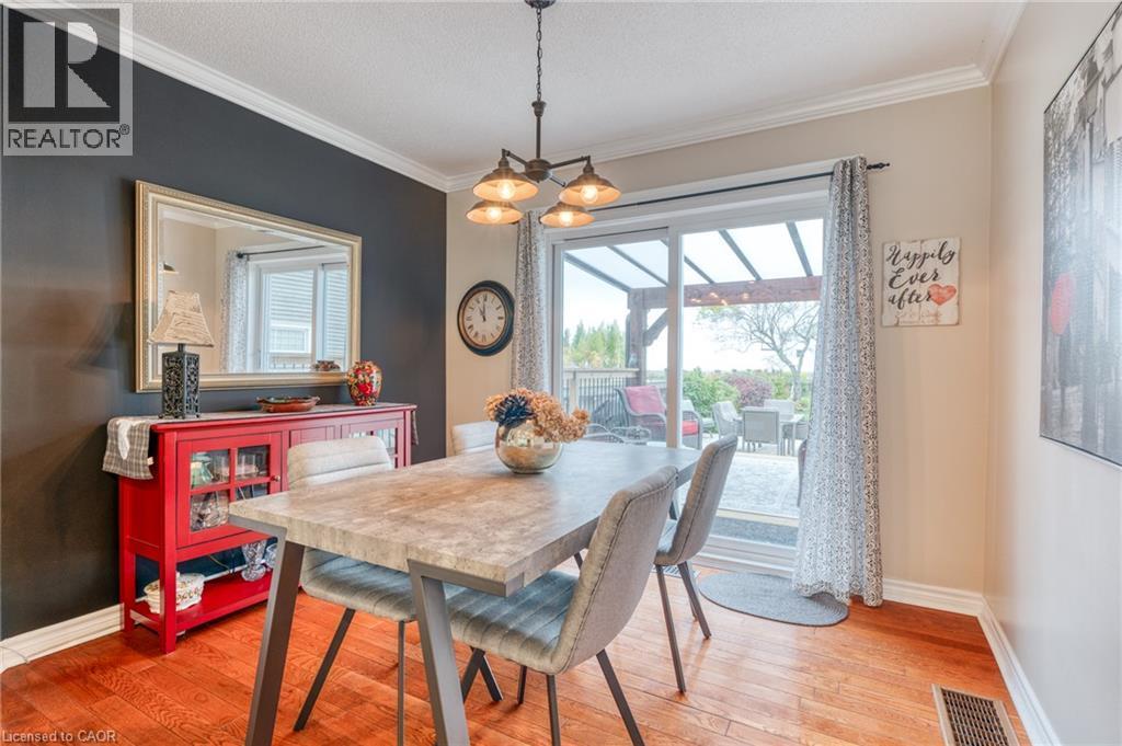 Dining area featuring rich wood-finish flooring, crown molding, and a sliding glass door providing direct access to the outdoor patio - 851 Beach Boulevard, Hamilton, ON - Indoor Photo Showing Dining Room