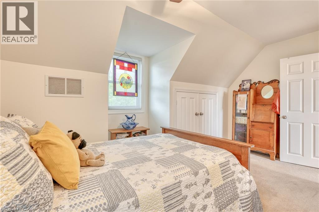 Bedroom featuring a sloped ceiling, carpet flooring, and a window with an artistic glass panel - 851 Beach Boulevard, Hamilton, ON - Indoor Photo Showing Bedroom