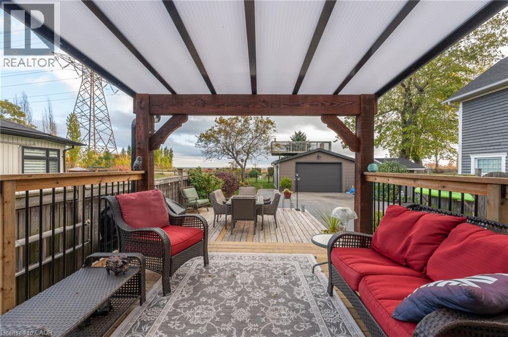 Expansive outdoor deck featuring a wooden railing with black balusters, a wood-beam pergola structure, and a translucent panel roof - 851 Beach Boulevard, Hamilton, ON - Outdoor With Deck Patio Veranda With Exterior