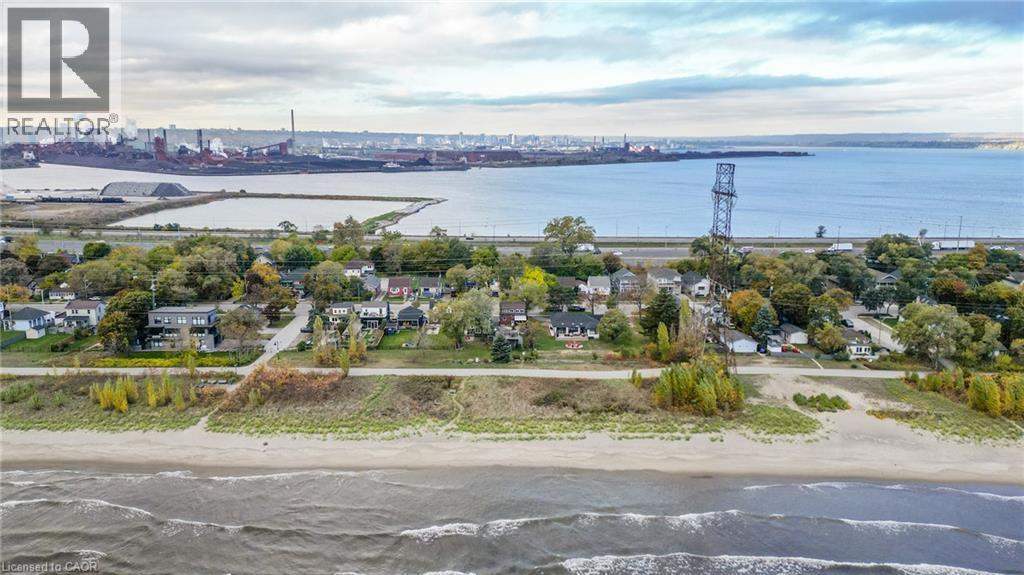 Expansive waterfront property featuring a sandy beach, mature trees, and direct access to Lake Ontario - 851 Beach Boulevard, Hamilton, ON - Outdoor With Body Of Water With View