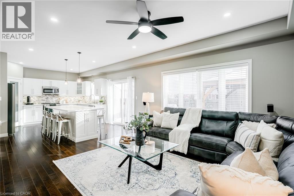 Open-concept living space featuring rich wood-finish flooring, recessed lighting, and a modern ceiling fan - 7 Kinsman Drive, Binbrook, ON - Indoor Photo Showing Living Room