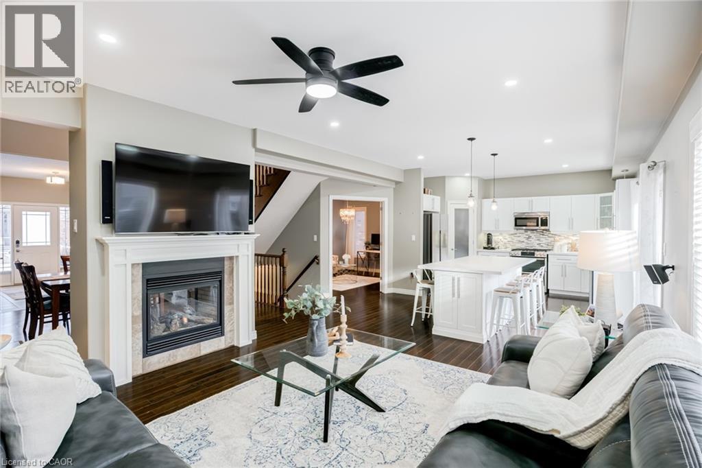 Open-concept living area featuring dark wood-finish flooring - 7 Kinsman Drive, Binbrook, ON - Indoor Photo Showing Living Room With Fireplace