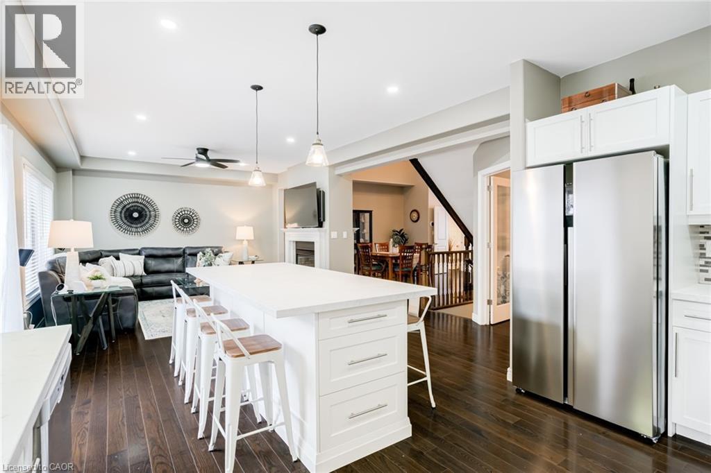 Kitchen featuring a large white island with seating, stainless steel side-by-side refrigerator, white cabinetry, and recessed lighting - 7 Kinsman Drive, Binbrook, ON - Indoor Photo Showing Kitchen With Upgraded Kitchen