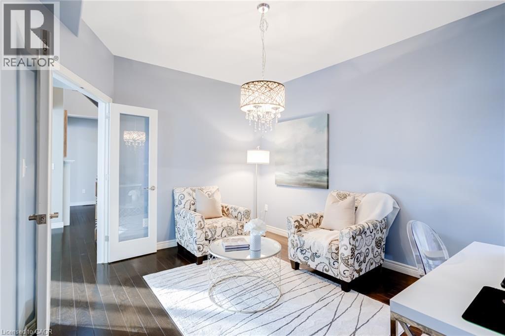 Room featuring dark wood-finish flooring, light blue walls, and a crystal chandelier - 7 Kinsman Drive, Binbrook, ON - Indoor