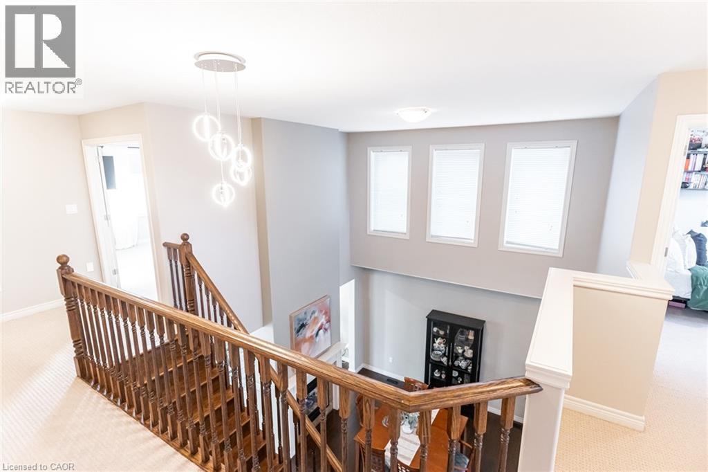 Upper-level landing featuring a contemporary chandelier and carpeted flooring - 7 Kinsman Drive, Binbrook, ON - Indoor Photo Showing Other Room