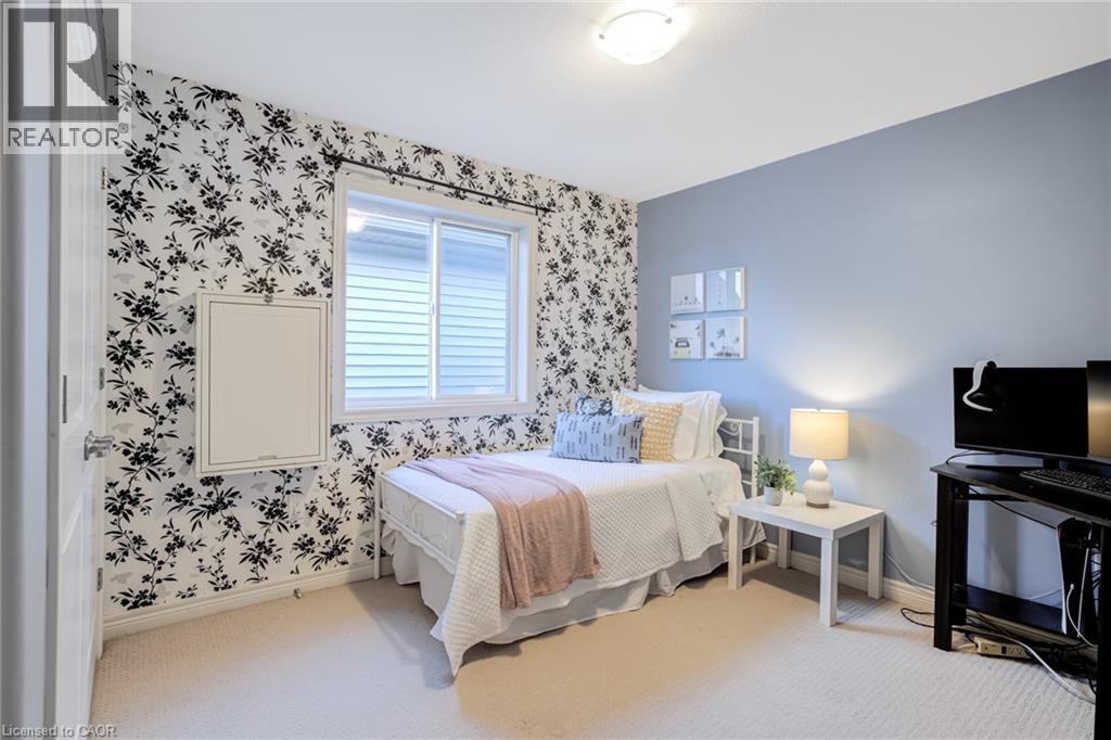 Carpeted room featuring a white paneled door, a sliding window with horizontal blinds, and a built-in wall panel - 7 Kinsman Drive, Binbrook, ON - Indoor Photo Showing Bedroom