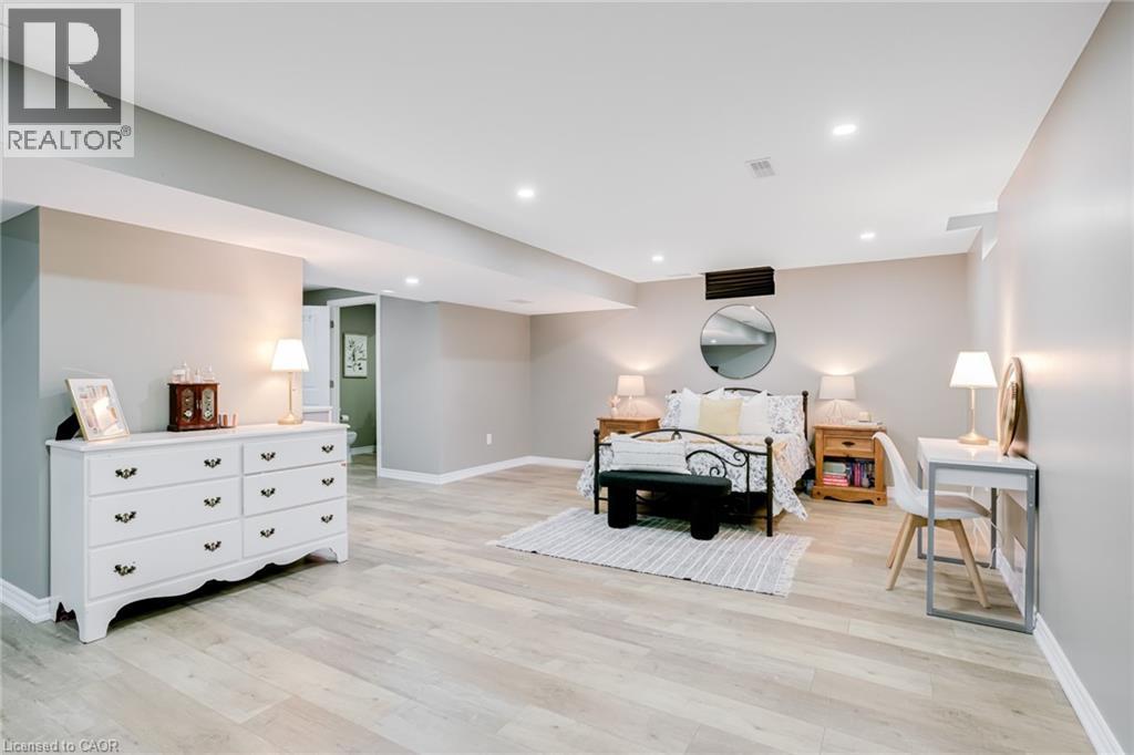 Spacious room featuring light wood-finish flooring, recessed lighting, and neutral wall tones - 7 Kinsman Drive, Binbrook, ON - Indoor