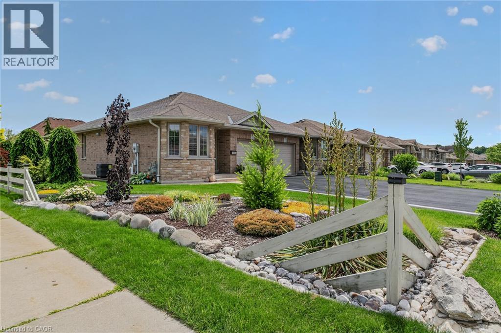 Brick and stone exterior with an attached garage, bay window, and a gabled roofline - 51 Millcroft Drive, Simcoe, ON - Outdoor