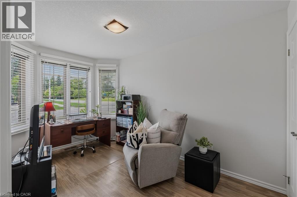 Bay window with multiple panels, wood-finish flooring, a neutral wall color, and a flush-mount ceiling light - 51 Millcroft Drive, Simcoe, ON - Indoor Photo Showing Office