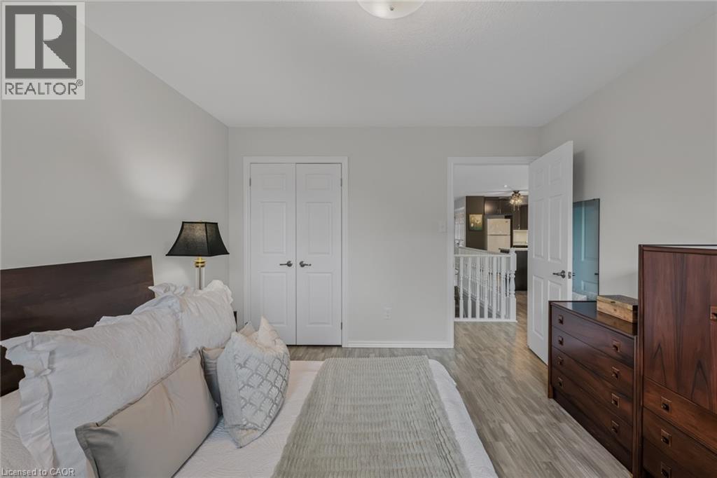 Bedroom featuring light gray wall paint, wood-finish flooring, and white bi-fold closet doors - 51 Millcroft Drive, Simcoe, ON - Indoor Photo Showing Bedroom
