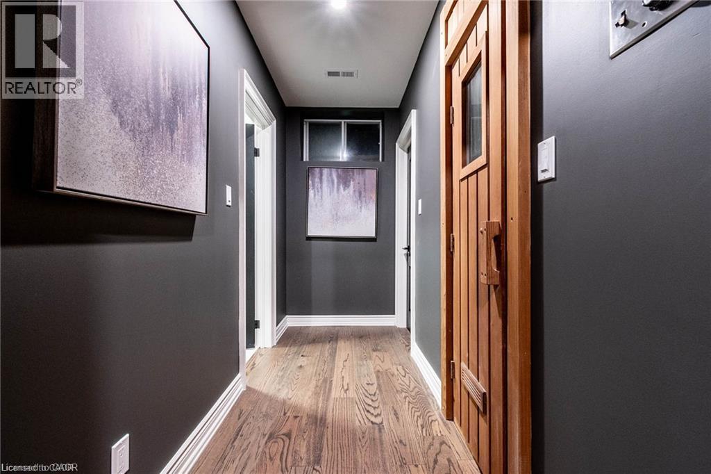 Hallway featuring wood-finish flooring and dark gray walls - 76 Adriatic Boulevard, Hamilton, ON - Indoor Photo Showing Other Room