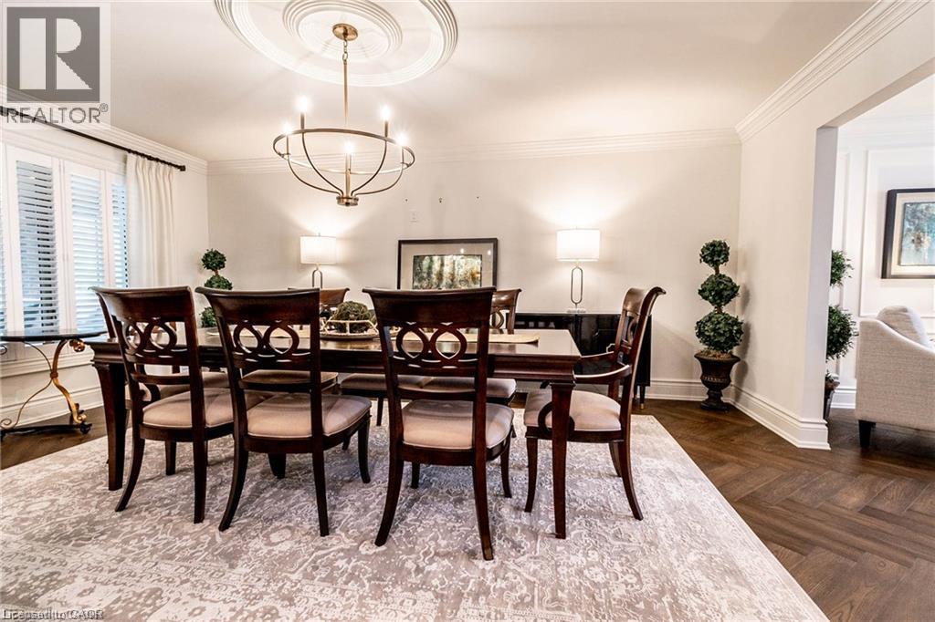 Dining area featuring herringbone wood-finish flooring, an ornate ceiling medallion, and a chandelier - 76 Adriatic Boulevard, Hamilton, ON - Indoor Photo Showing Dining Room