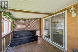 Covered porch featuring wood-finish flooring, a built-in bench, and lattice privacy screening -