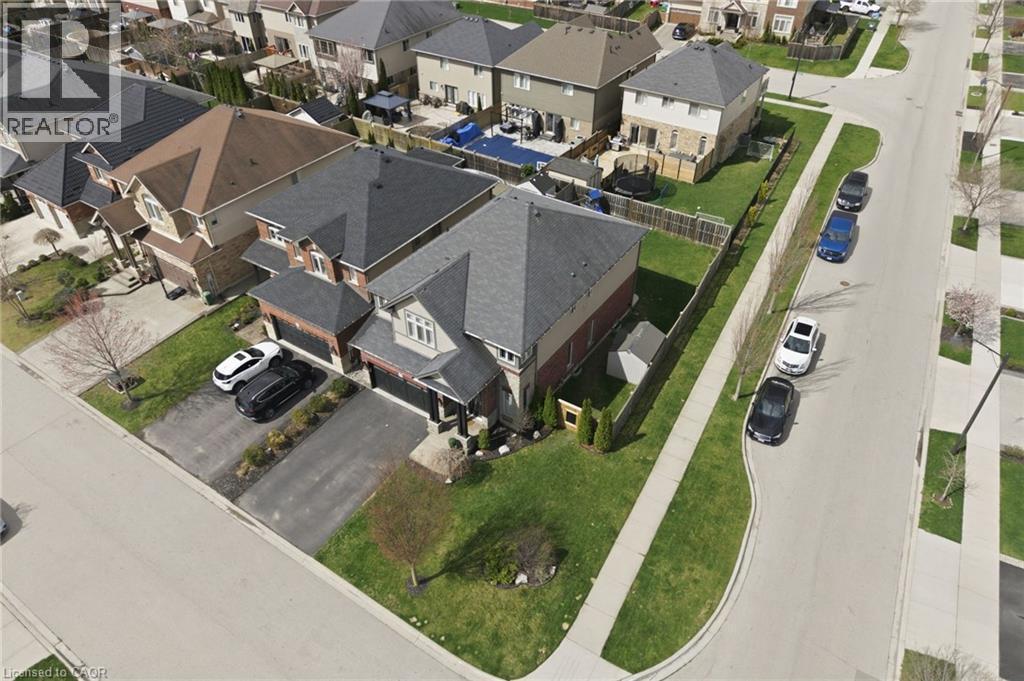 Suburban residential property featuring a gray shingle roof, light-colored siding, and brick accents - 47 Winners Way, Binbrook, ON -