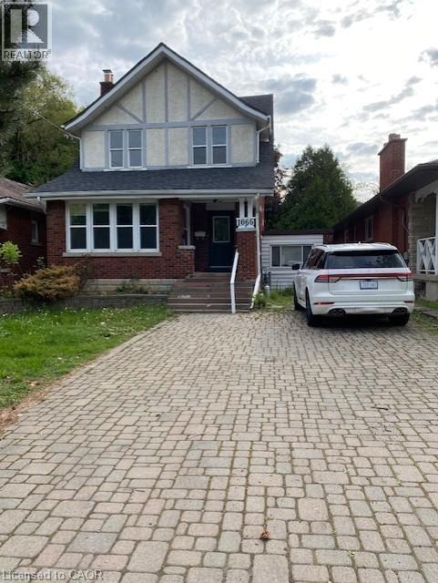 Brick and stucco Tudor Revival style home featuring a gabled roofline and multiple windows - 1066 Richmond Street, London, ON - Outdoor With Facade