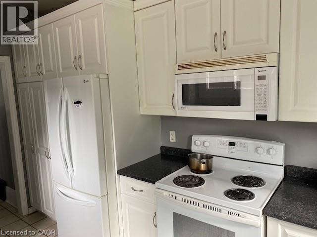 Kitchen featuring white cabinetry, dark speckled countertops, and an electric range with an over-the-range microwave - 1066 Richmond Street, London, ON - Indoor Photo Showing Kitchen