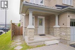 Front entry featuring a covered porch with stone-clad columns, a main door with decorative glass, and brick and stone veneer exterior -