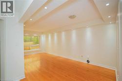 Spacious room featuring wood-finish flooring, recessed ceiling lighting, a large window, and light-toned wall finishes -
