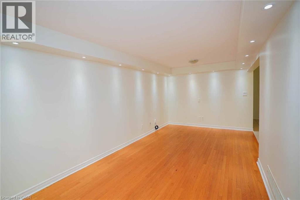 Hardwood flooring throughout a spacious room with recessed lighting and a neutral color palette - 18 Heritage Drive, Guelph, ON - Indoor Photo Showing Other Room