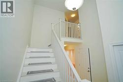 Two-story entryway featuring a white painted staircase with matching banister and balusters -