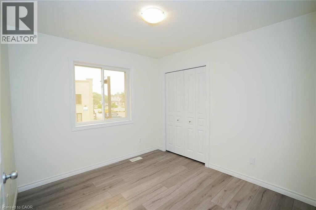 Room featuring light wood-finish flooring, white walls, and a white ceiling with a flush-mount light fixture - 18 Heritage Drive, Guelph, ON - Indoor Photo Showing Other Room