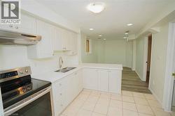 Contemporary kitchen featuring white cabinetry, stainless steel appliances, a double basin sink, and a peninsula with countertop seating -