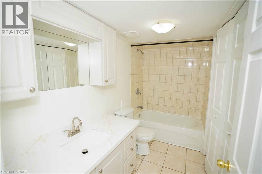 Bathroom featuring a white vanity with integrated sink, white cabinetry, and a full-width mirror - 18 Heritage Drive, Guelph, ON - Indoor Photo Showing Bathroom
