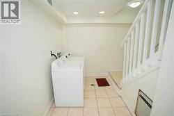 Dedicated laundry area featuring tile flooring and recessed lighting -