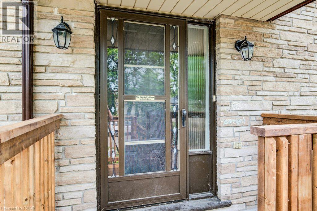 Stone veneer exterior with a storm door featuring decorative glass inserts and a full-length sidelight - 109 White Oak Place, Waterloo, ON - With Exterior