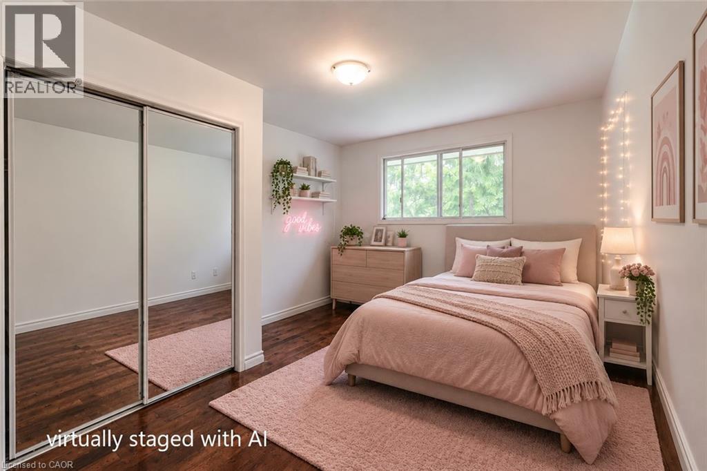 Bedroom featuring dark wood-finish flooring, white baseboards, and a large window - 109 White Oak Place, Waterloo, ON - Indoor Photo Showing Bedroom