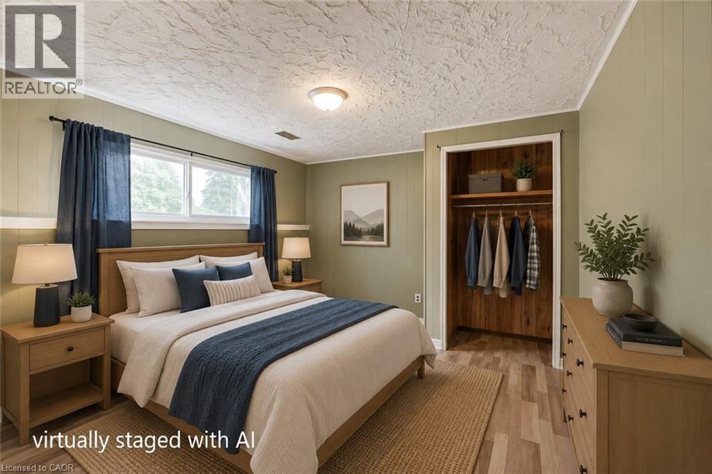 Bedroom featuring a wood-finish flooring, two window openings, and a built-in closet with shelving and hanging rod - 109 White Oak Place, Waterloo, ON - Indoor Photo Showing Bedroom