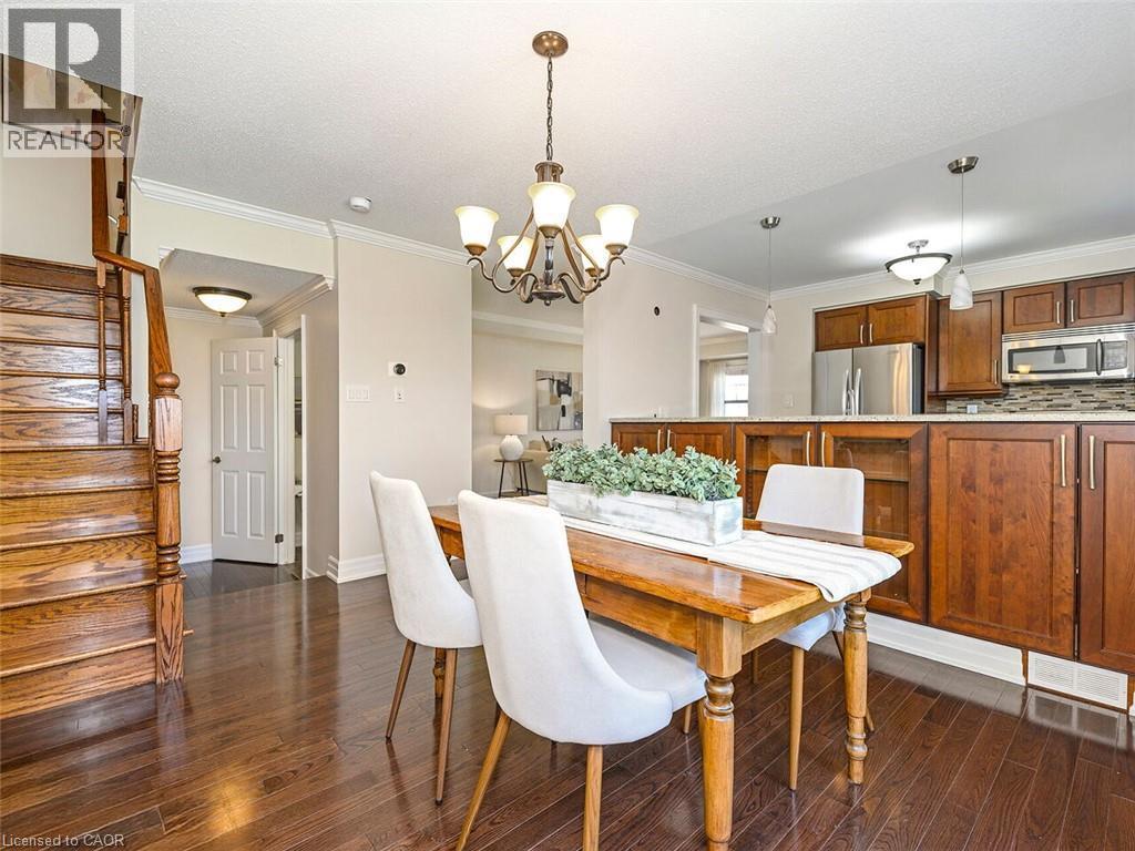 Dining area featuring wood-finish flooring, a traditional chandelier, and crown molding - 656 Frank Place, Milton, ON - Indoor Photo Showing Dining Room