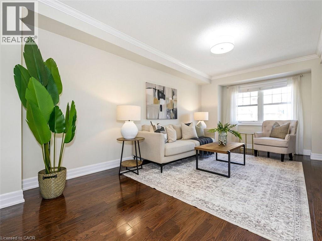 Living area featuring rich wood-finish flooring, white baseboards, and crown molding - 656 Frank Place, Milton, ON - Indoor Photo Showing Living Room
