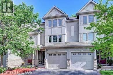 Multi-level townhouse exterior featuring light-toned siding and brick veneer accents - 175 David Bergey Drive Unit# L74, Kitchener, ON - Outdoor