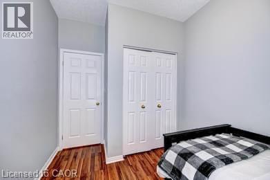 Wood-finish flooring with white baseboards throughout - 175 David Bergey Drive Unit# L74, Kitchener, ON - Indoor Photo Showing Bedroom