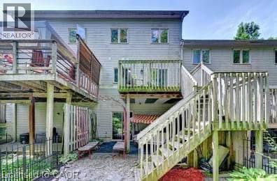 Multi-level decks with wood railings, steps, and privacy screening provide extensive outdoor living space - 175 David Bergey Drive Unit# L74, Kitchener, ON - Outdoor