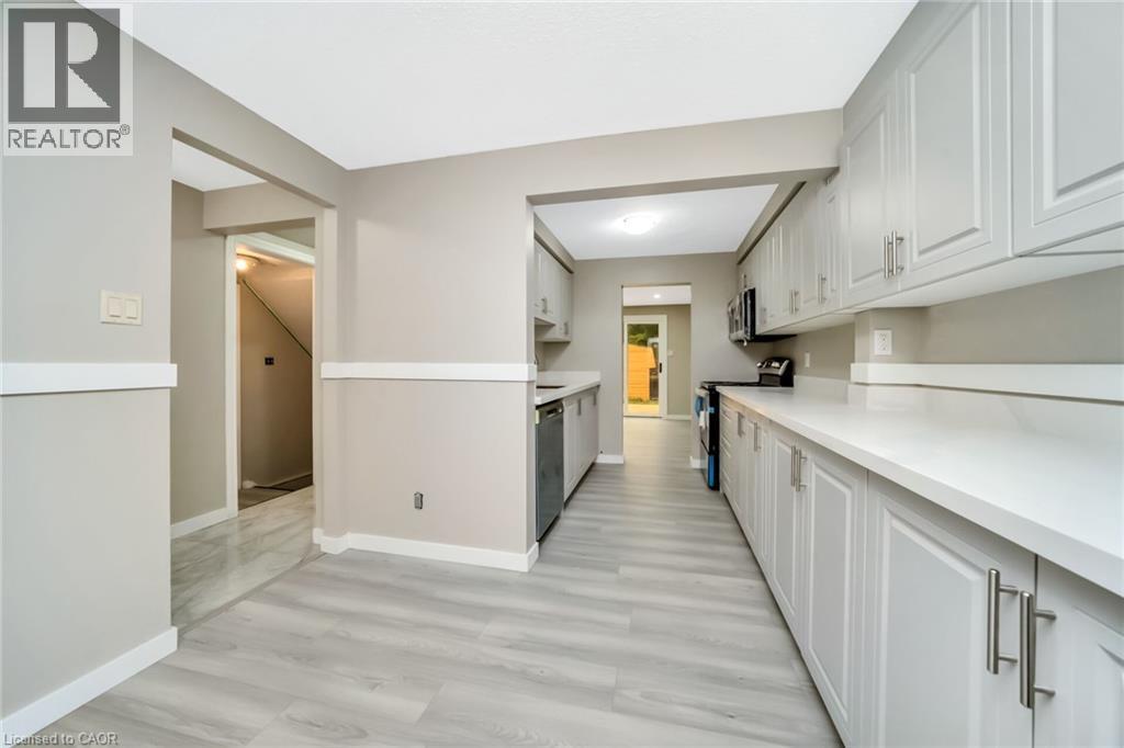 Kitchen featuring light grey cabinetry, white countertops, stainless steel appliances, and wood-finish flooring - 53 Burns Drive, Guelph, ON - Indoor Photo Showing Kitchen