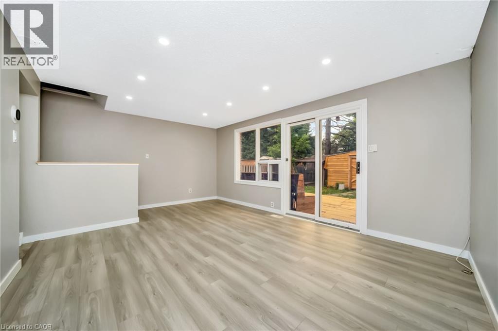 Spacious room featuring light-toned wood-finish flooring, recessed ceiling lighting, and a neutral wall color - 53 Burns Drive, Guelph, ON - Indoor Photo Showing Other Room