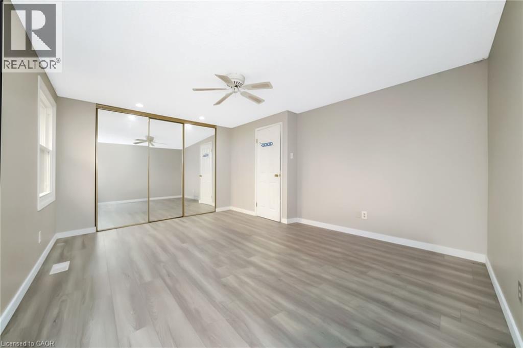 Room featuring light gray wood-finish flooring, a ceiling fan, and a window with white trim - 53 Burns Drive, Guelph, ON - Indoor Photo Showing Other Room