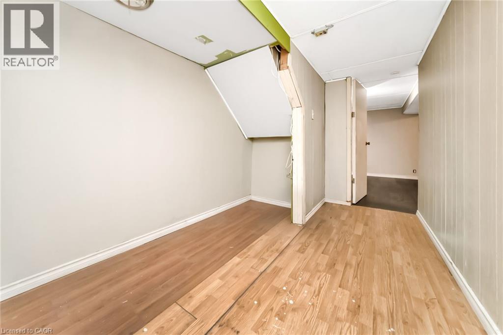 Interior room with wood-finish flooring, white baseboards, and light-toned walls - 53 Burns Drive, Guelph, ON - Indoor Photo Showing Other Room