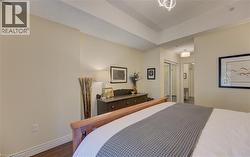 Spacious room with tray ceiling, wood-finish flooring, and light-colored walls -