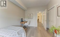 Light-toned wide plank flooring extending through the room, featuring neutral wall paint and white trim -